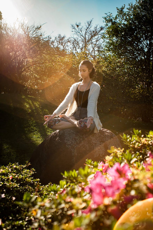 woman meditating on rock