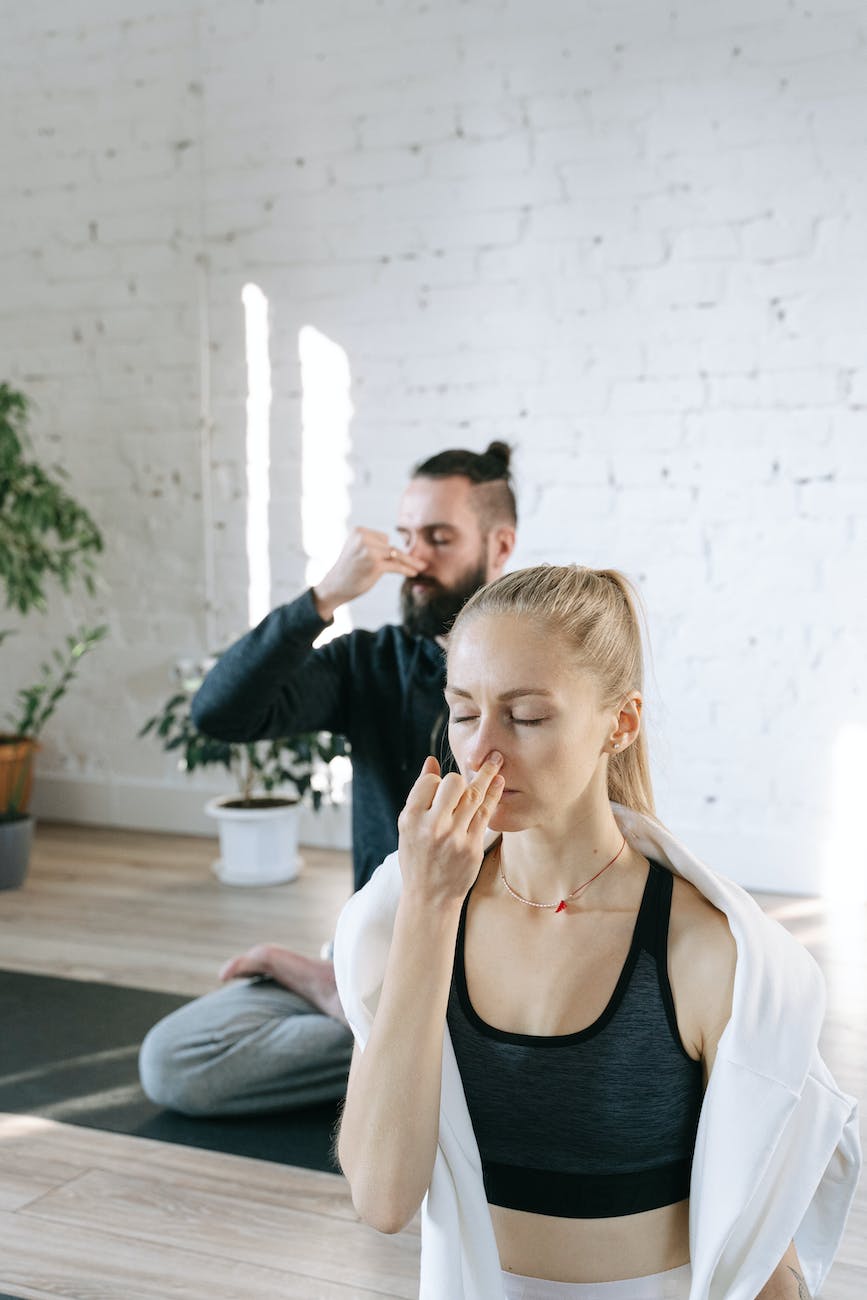 a man and a woman holding their noses for breathing control exercise